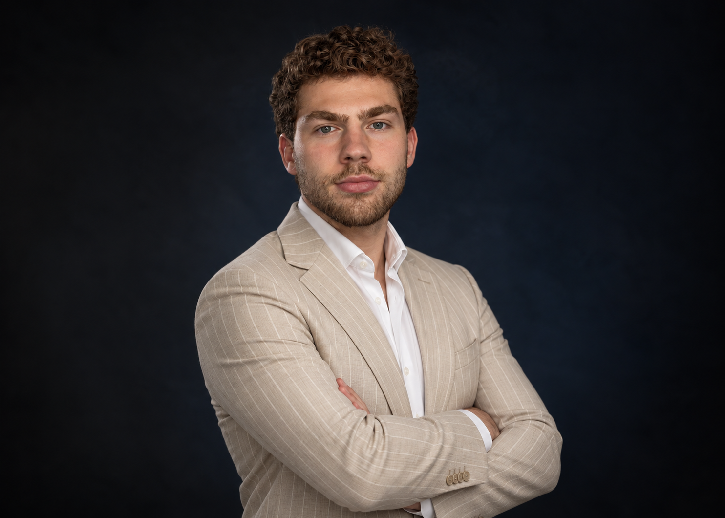 Morrisson, founder of Easy Homes Eindhoven, in a beige pinstripe jacket against a dark studio backdrop